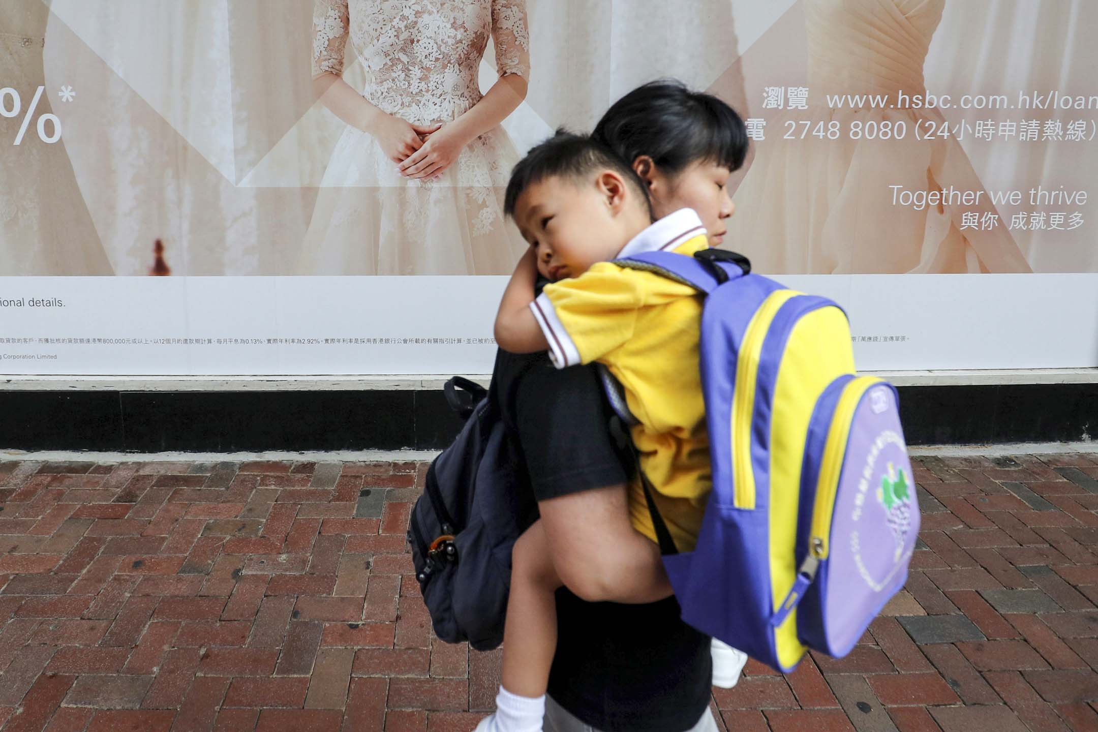 香港一位母亲抱著孩子上学。摄：Amr Abdallah Dalsh/Reuters/ 达志影像