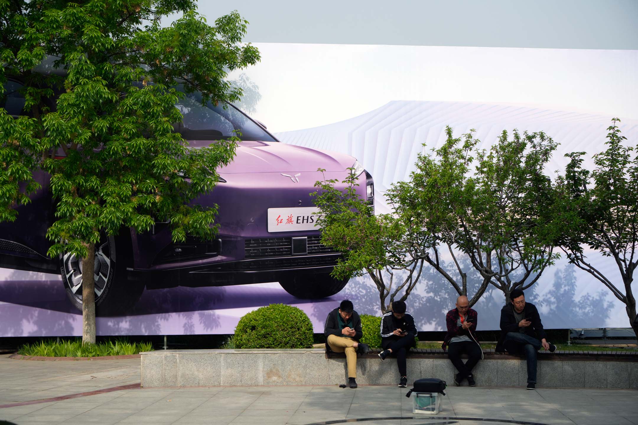 2024 年 4 月 25 日，中国北京，车展外的电动汽车广告。摄：Qilai Shen/Bloomberg via Getty Images