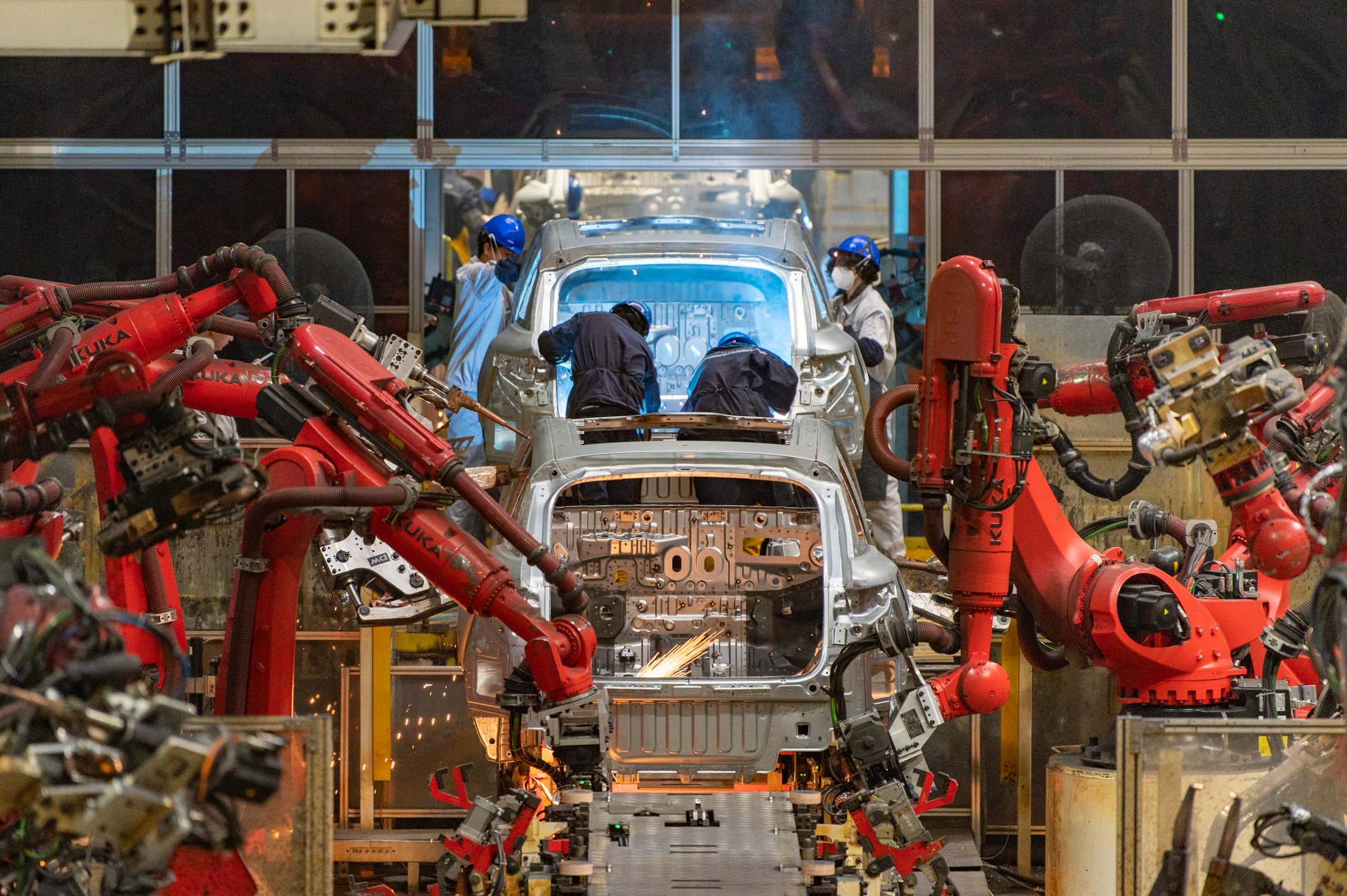 2024 年 4 月 8 日，中国金华，工人们正在电动汽车工厂上组装汽车。摄：Hu Xiaofei/VCG via Getty Images